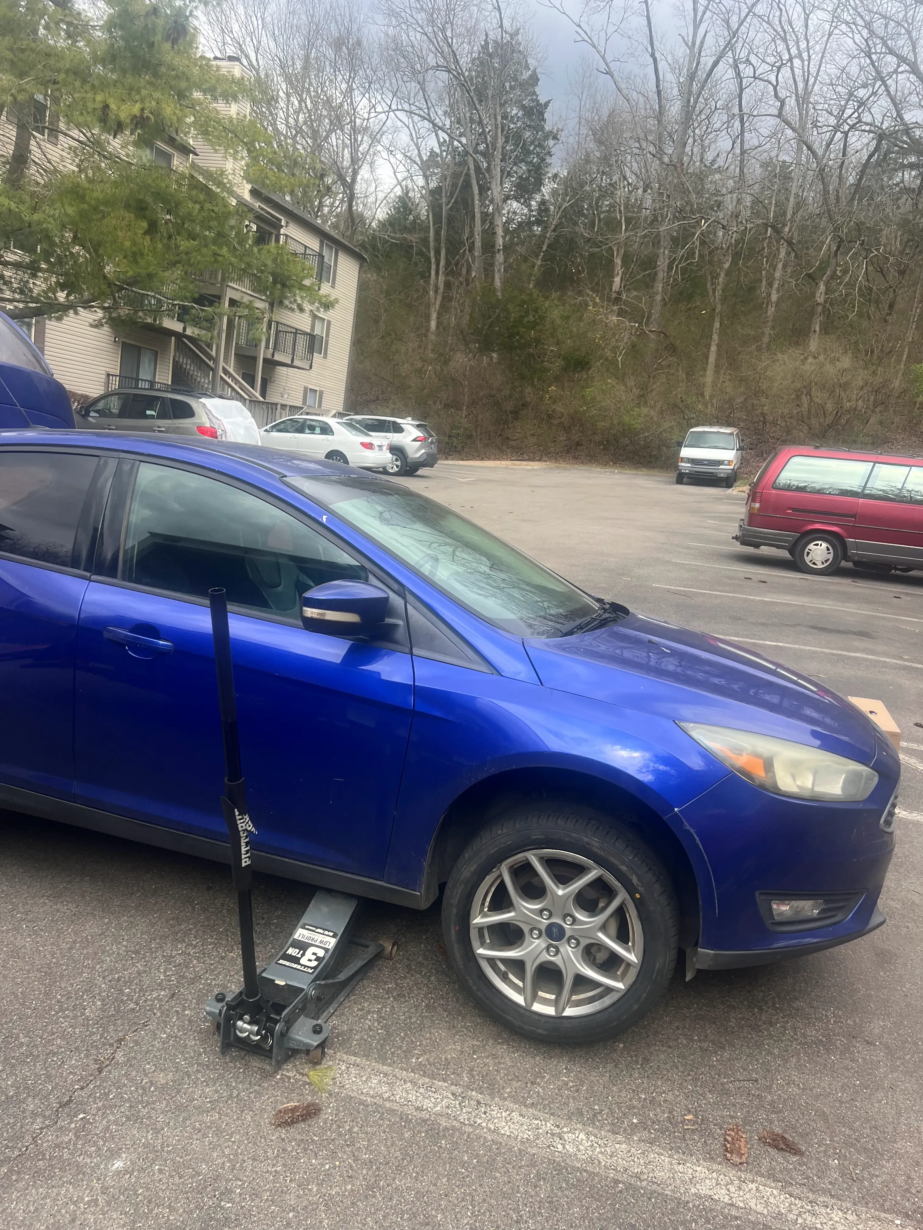 Mobile tire replacement on a blue Ford passenger vehicle in Nashville — wheel removed and a fresh tire being mounted on-site by a Nashville Flat Tire Service technician.